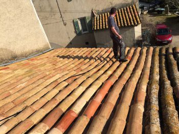 Homme nettoyant une toiture en tuile abimée à Lançon de Provence